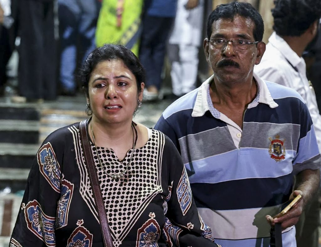 Emotional woman and man at Kolkata Durga Puja stampede scene, distressed and concerned.
