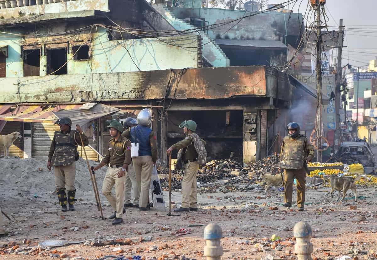 A security personnel stands guard near a neighborhood vandalized by rioters during clashes between those against and those supporting the Citizenship (Amendment) Act in northeast Delhi.
