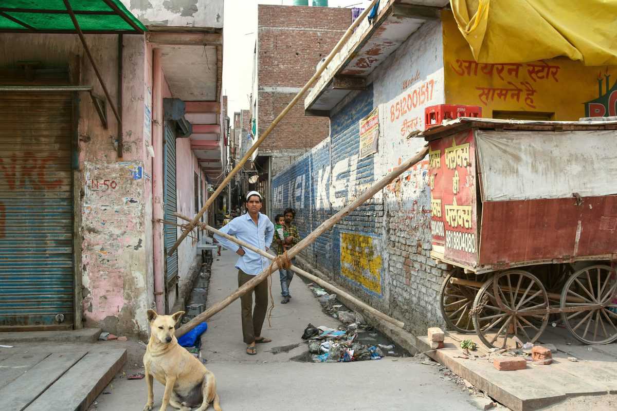 A local stands near a barricaded street following Tuesday's clashes over the new citizenship law, at Brij Puri area of northeast Delhi.