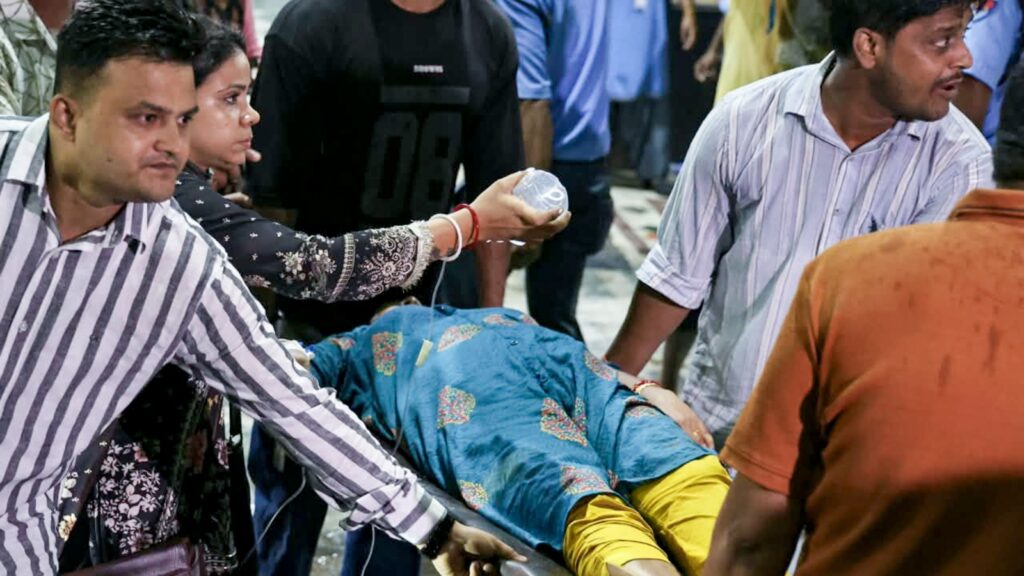 People assisting an injured person during a chaotic scene in Kolkata.