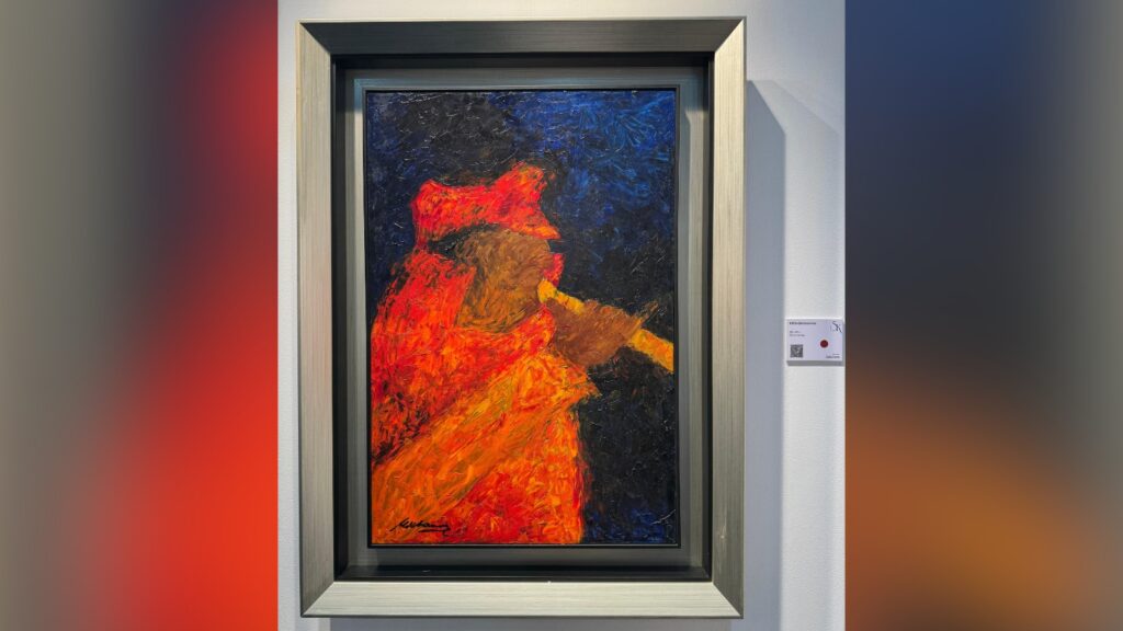 Abstract painting with vibrant red, orange, and blue colours in a silver frame.