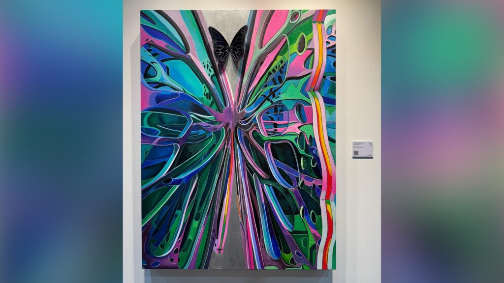 Vibrant abstract butterfly painting with a black butterfly at the centre, colourful wings, and dynamic sw.