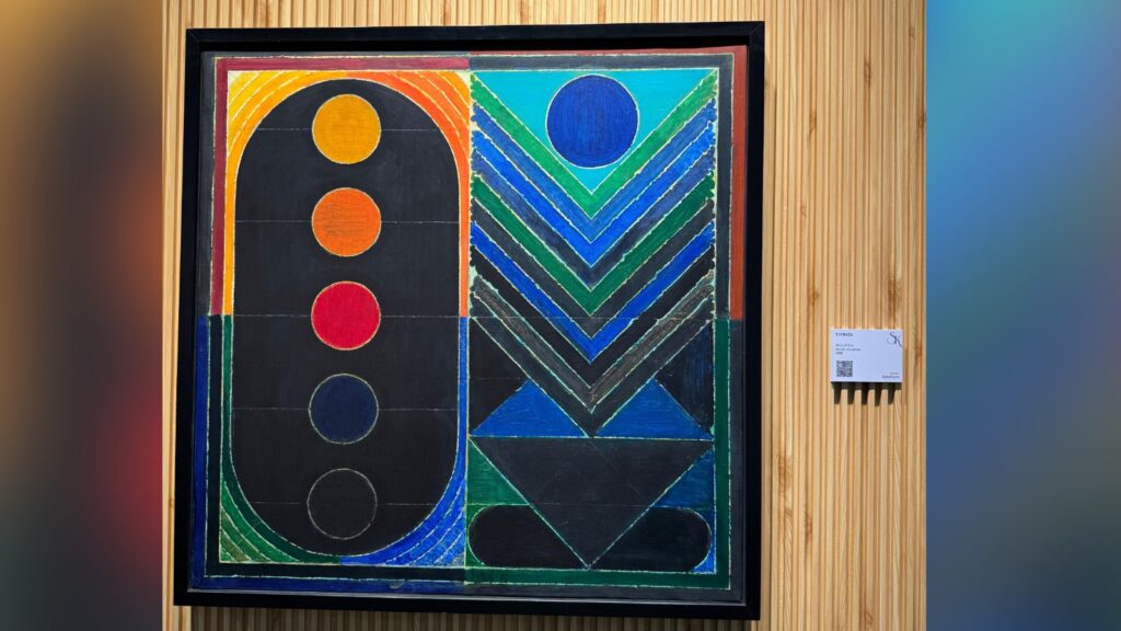 Abstract geometric artwork with vibrant colours and bold shapes displayed in a frame.