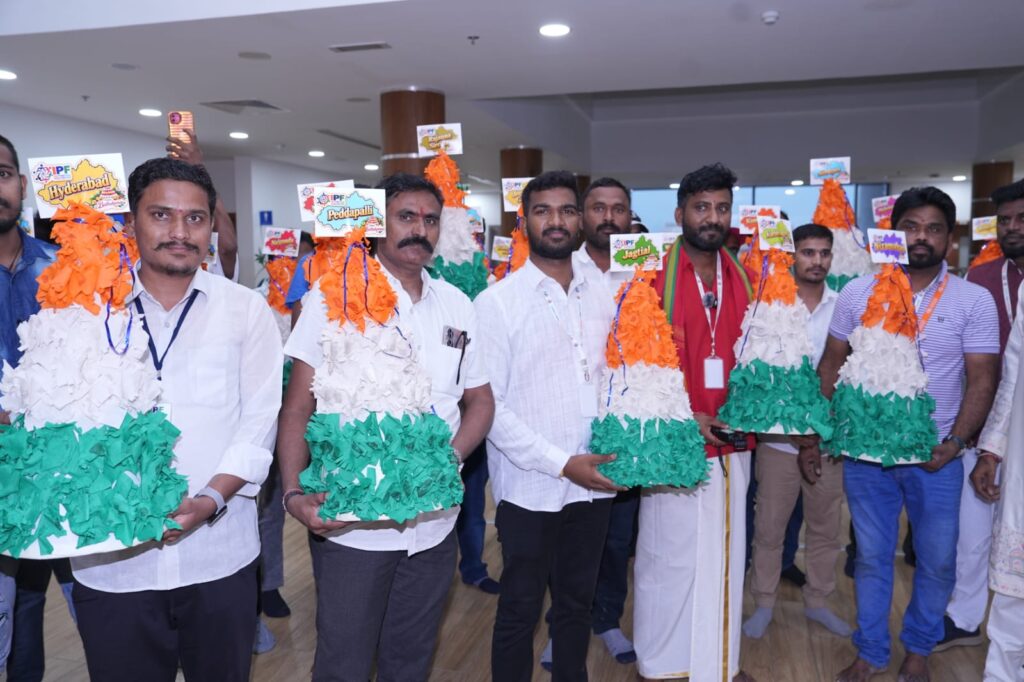 Group of men holding colourful Bathukamma flower arrangements at Dubai event.